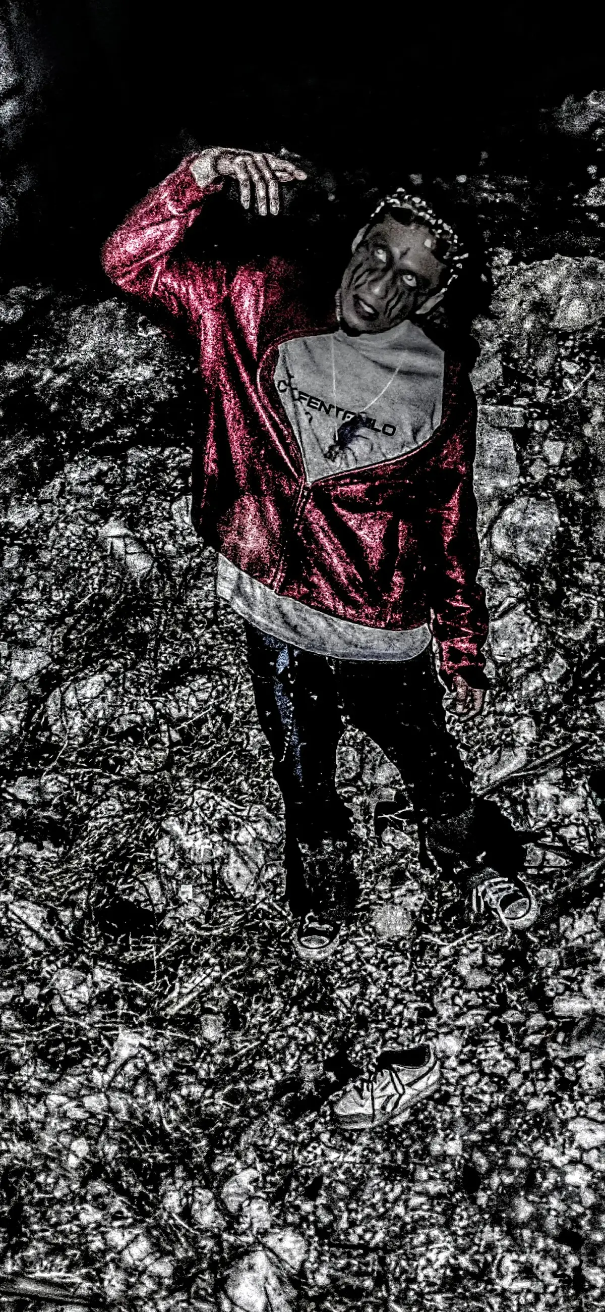 Figura con sudadera roja metálica de pie sobre escombros