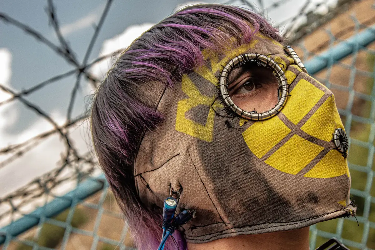 Perfil con máscara de tela cosida a mano, amarilla y café, y pelo morado
